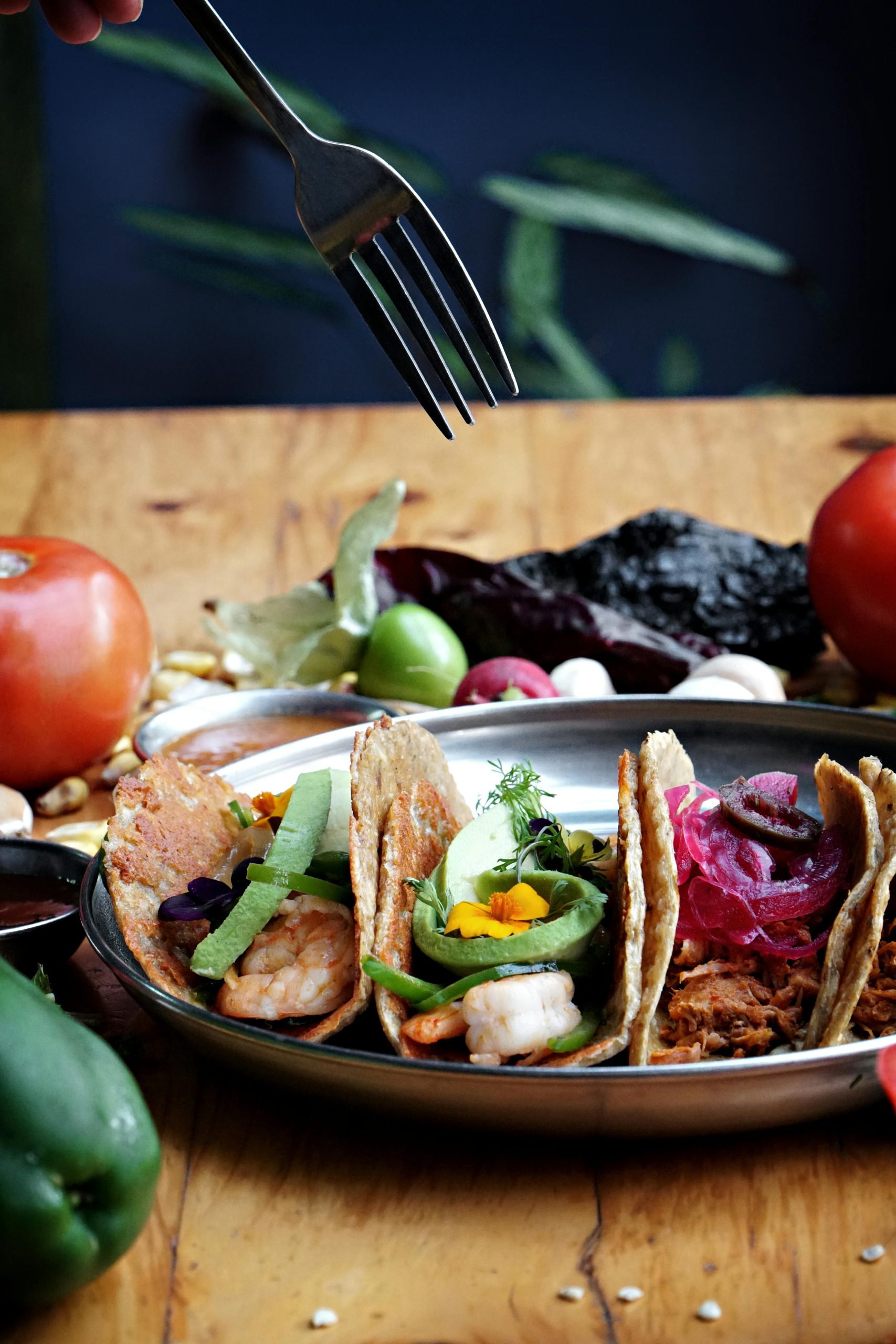 Vibrant display of traditional Mexican tacos with fresh vegetables and herbs, perfect for culinary exploration.